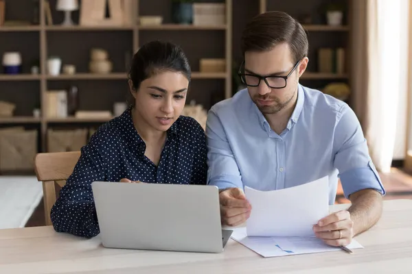 Geconcentreerde medewerkers van gemengde rassen die aan online projecten werken. — Stockfoto