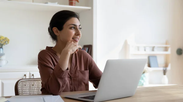 Femme indienne s'asseoir à table avec ordinateur portable pensée regarde de côté — Photo