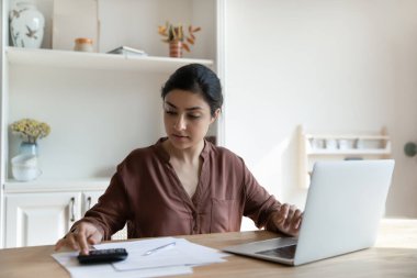 Odaklanmış Hintli kadın internet üzerinden fatura ve vergi ödemelerini hesaplıyor.