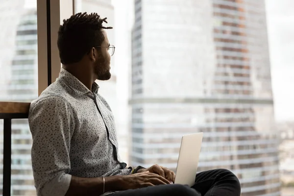 Soñador inteligente joven afroamericano freelancer trabajando en la computadora. —  Fotos de Stock