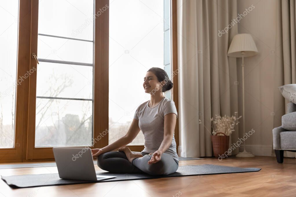 Serene Indian female trainer lead online yoga meditation class