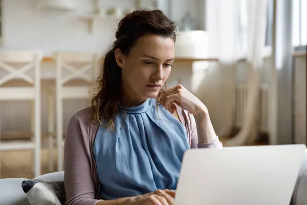 Mujer joven reflexiva mirando la pantalla de la computadora. —  Fotos de Stock