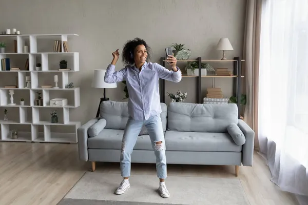 Pełna długość Afroamerykanka w słuchawki taniec, trzymając smartfon — Zdjęcie stockowe