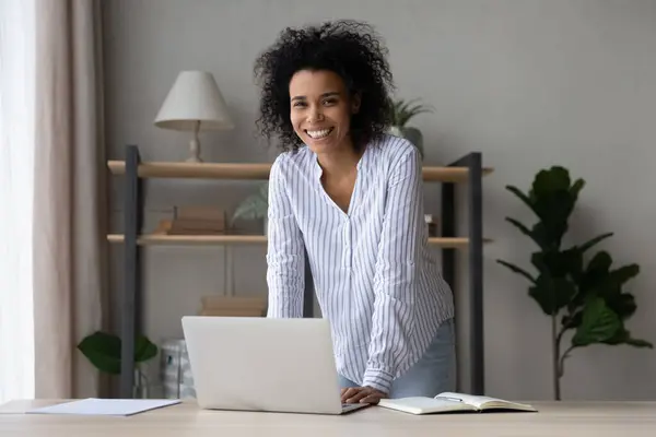 Portret lachende Afro-Amerikaanse vrouw staat in de buurt van het bureau — Stockfoto
