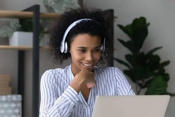 Head shot smiling African American woman in headphones watching video — Stock Photo, Image