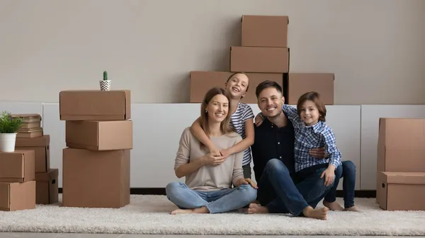 Retrato de familia feliz con niños disfrutando de un día de mudanza — Foto de Stock