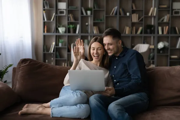 Felice coppia che abbraccia le mani agitando, chatta online tramite videochiamata — Foto Stock