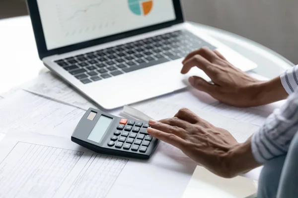 Cropped close up African American woman calculating bills, using laptop — Stock Photo, Image