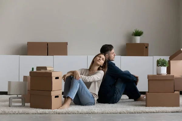 Cansada pareja infeliz sentada en el suelo con cajas de cartón — Foto de Stock