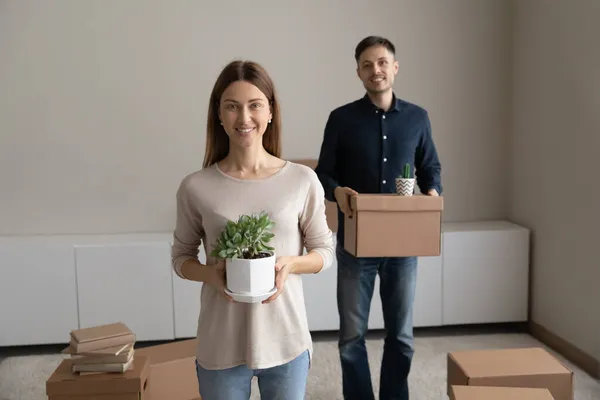 Retrato feliz pareja disfrutando de un día en movimiento, sosteniendo la caja de cartón — Foto de Stock
