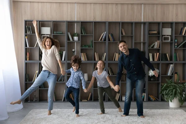 Retrato engraçado família alegre com dois filhos de mãos dadas, pulando — Fotografia de Stock