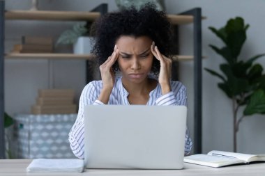 Mutsuz Afrikalı Amerikalı iş kadını şakaklara dokunuyor, baş ağrısı çekiyor.