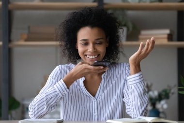 Kafasına gülümseyen Afrikalı Amerikalı kadın iş kadını sesli mesaj kaydediyor.