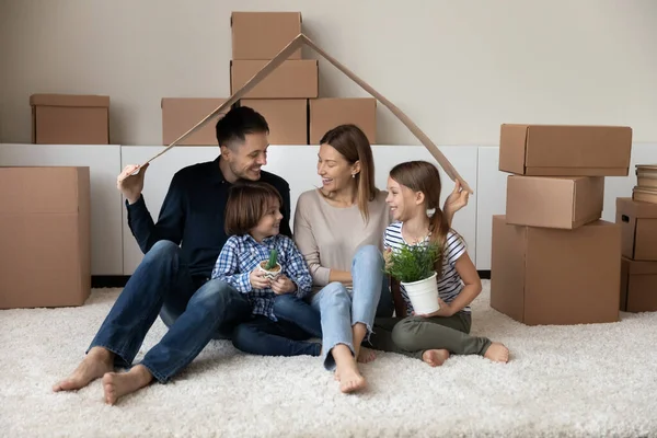 Feliz familia disfrutando de un día en movimiento, divirtiéndose en un nuevo hogar — Foto de Stock