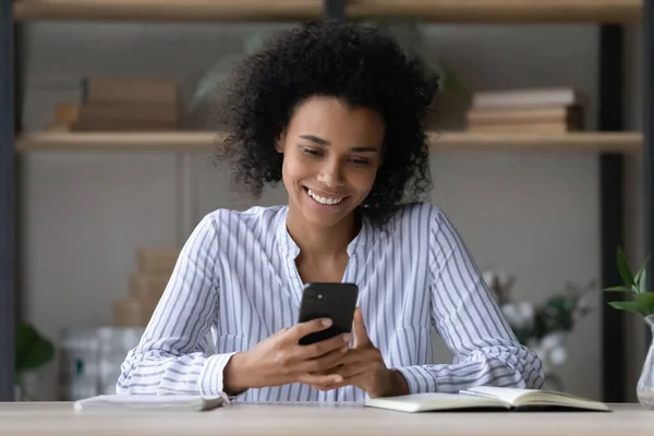Head shot smiling African American woman using smartphone, chatting online — Stock Photo, Image