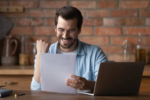 Happy young man analyst reading marketing report raising hand super — Stock Photo, Image