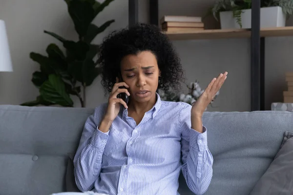 Olycklig afroamerikansk kvinna pratar i telefon hemma — Stockfoto