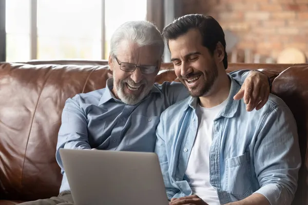 El padre anciano y el niño adulto usan la computadora para ir de compras por la web — Foto de Stock