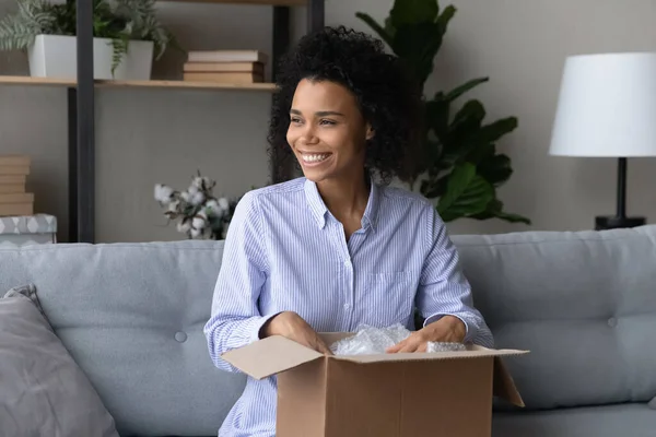 Sorridente cliente afroamericano donna sentirsi soddisfatti, pacco disimballaggio — Foto Stock