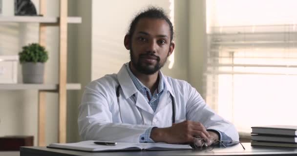 Счастливый молодой африканский врач позирует в современной клинике. — стоковое видео