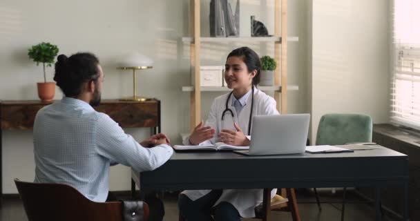 Gelukkige Indiaanse arts in gesprek met Afrikaanse patiënt. — Stockvideo