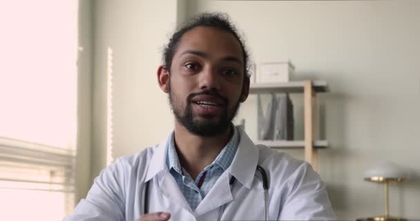 Glücklicher afrikanischer Arzt berät Patientin per Videoanruf. — Stockvideo