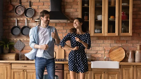 Jeune couple familial actif sauter par la musique disco à la cuisine — Photo