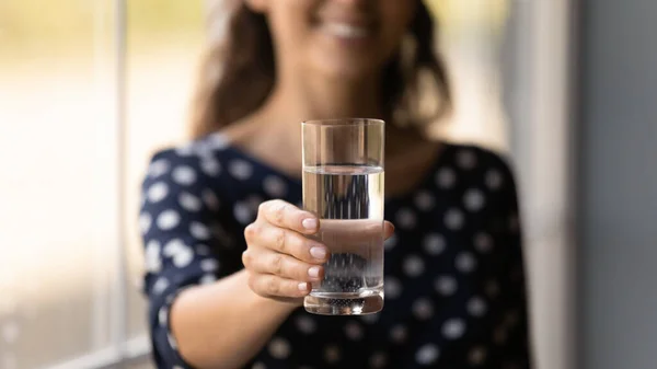 Haut verre d'aqua minéral naturel frais dans la main de la femme — Photo