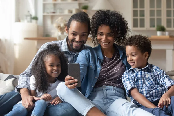 Padres felices y lindos hijos hermanos viendo contenido de medios en línea — Foto de Stock