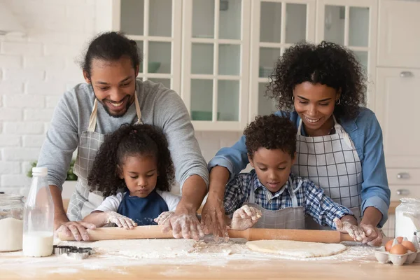 Alegre joven negro pareja y poco niños hornear pastel juntos —  Fotos de Stock