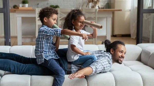 Glücklicher Papa und Kinder spielen lustige aktive Spiele auf der Couch — Stockfoto