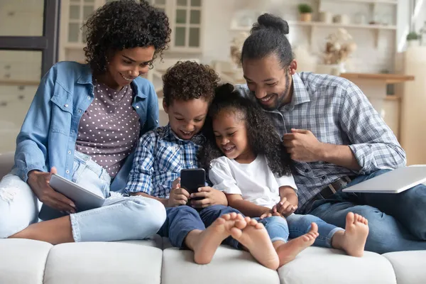 Szczęśliwa rodzina para, mały syn i córka za pomocą cyfrowych gadżetów — Zdjęcie stockowe