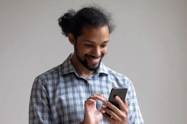 Glad tusenårig svart kille läser sms på mobiltelefon — Stockfoto