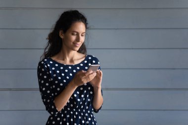 Gülümseyen genç İspanyol kadın sohbet oyunu telefon cihazında