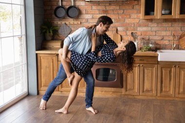 Çıplak ayaklı milenyum eşleri dans partnerleri mutfakta tutkulu bir tango yapıyorlar.