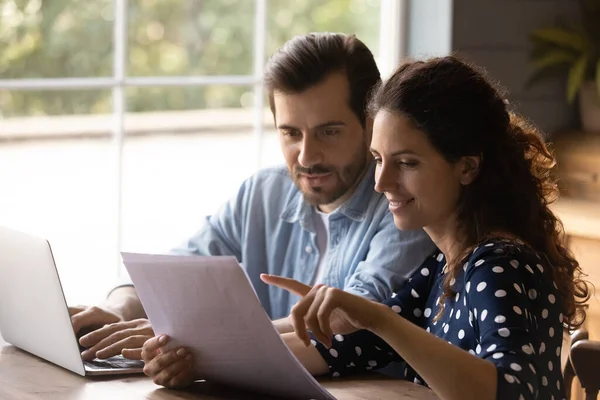 Jonge echtgenoten houden bankrekeningafschrift controleren financiële gegevens online — Stockfoto