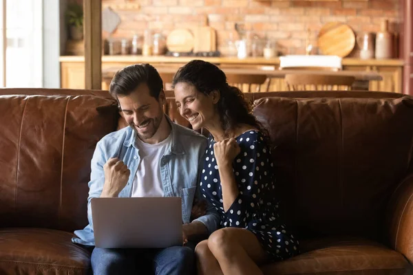 Casal feliz casal sentar no sofá usar laptop rir sim — Fotografia de Stock