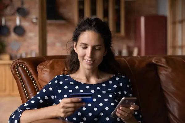 Young female read bank card data to pay via cell — Stock Photo, Image