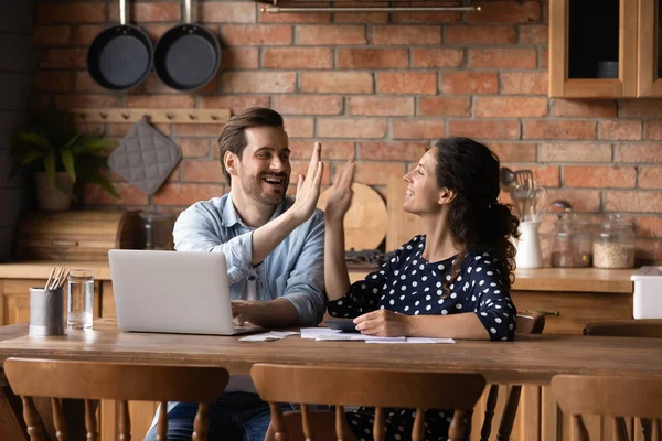 Emocionada joven familia pareja levantar cinco alto después de pagar las facturas — Foto de Stock