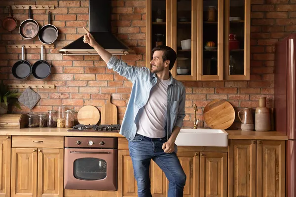 Divertente uomo millenario godere di danza di cucina in cucina moderna in legno — Foto Stock