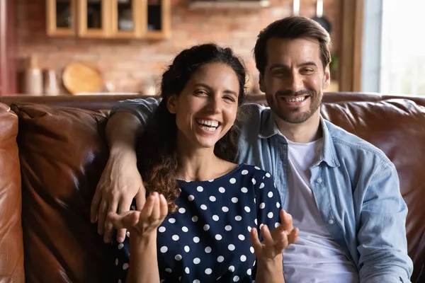 Junges Familienpaar umarmt sich auf Couch-Talk mit Digitalkamera — Stockfoto