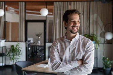 Modern ofiste poz veren mutlu, genç İspanyol iş adamı.