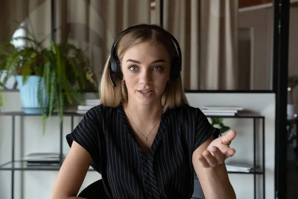 Jeune belle femme d'affaires en casque tenant une réunion par appel vidéo. — Photo