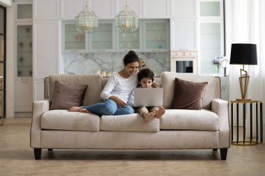 Mutlu genç Hintli anne ve heyecanlı küçük çocuk video oyunu oynuyorlar.