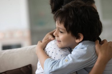 Mutlu Hintli anaokulu çocuğu sevgili annesini sevgiyle kucaklıyor.