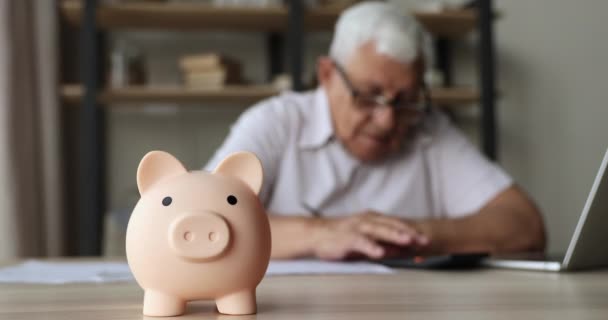 Старший мужчина пенсионера рассчитывать на калькулятор пытаются сэкономить деньги — стоковое видео