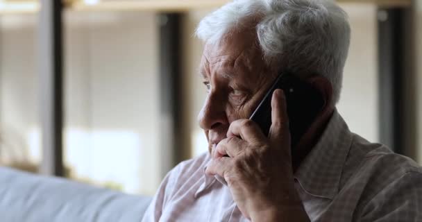 Starý děda s telefonem konverzace drží zařízení k uchu — Stock video