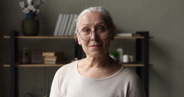 Ήρεμη ηλικιωμένη ηλικιωμένη γυναίκα με γυαλιά που ποζάρει στο σπίτι — Αρχείο Βίντεο