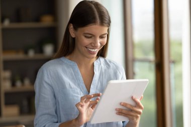 Dijital dokunmatik cihaz kullanan mutlu ve çekici bir kadın..