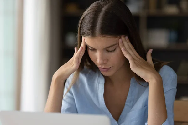 Egészségtelen fiatal nő szenved fejfájás az irodában. — Stock Fotó
